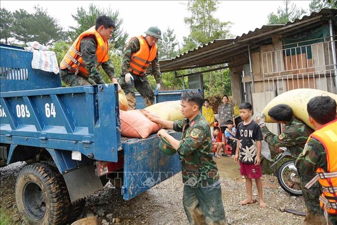Lực lượng quân đội giúp người dân Mường Than di dời tài sản đến nơi an toàn. Ảnh: Nguyễn Oanh - TTXVN
