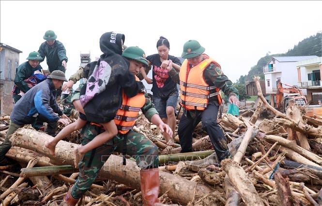 Lực lượng Quân đội đưa người dân ra khỏi nơi nguy hiểm do lũ quét gây ra. Ảnh: Quý Trung – TTXVN