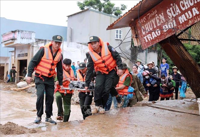 Lực lượng Công an đưa thi thể nạn nhân bị lũ cuốn trôi về để giao cho gia đình lo hậu sự. Ảnh: Quý Trung - TTXVN