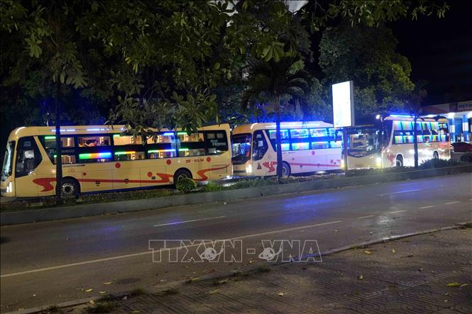 Xe khách của tại Công ty Cổ phần Vận tải du lịch Hưng Long nối đuôi nhau dừng, đỗ, đón trả khách ngay trên Quốc lộ 1A, nơi có biển cấm dừng, đỗ đối với xe khách. Ảnh: Tá Chuyên - TTXVN