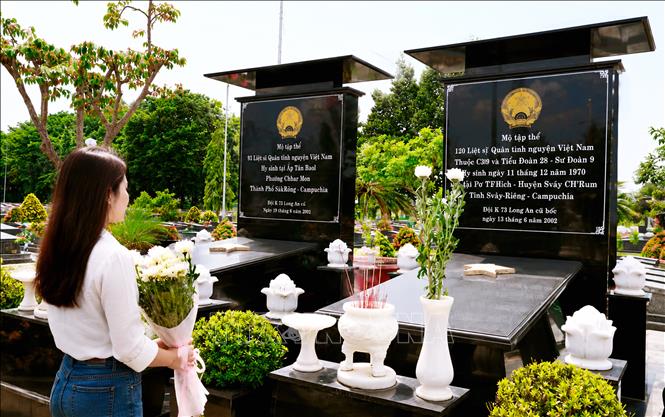 Người dân dâng hoa tưởng niệm các Anh hùng liệt sĩ tại ngôi mộ tập thể Nghĩa trang Vĩnh Hưng, tỉnh Tây Ninh. Ảnh: TTXVN phát