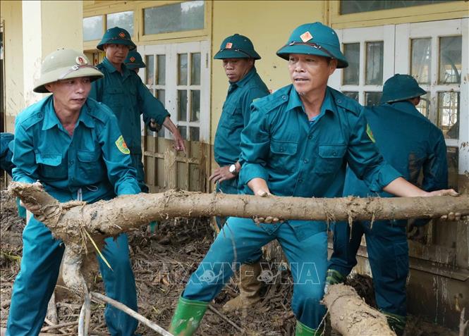 Lực lượng Dân quân tự vệ tỉnh Lai Châu giúp dân tại tâm lũ Mường Than khắc phục hậu quả cơn lũ. Ảnh: Nguyễn Oanh-TTXVN.