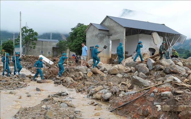 Đông đảo lực lượng dân quân tự vệ giúp dân khắc phục thiên tai. Ảnh: Nguyễn Oanh-TTXVN.