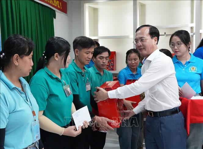 Phó Bí thư Tỉnh ủy, Chủ tịch UBND tỉnh Vĩnh Long Trần Trí Quang tặng quà cho đoàn viên công đoàn có hoàn cảnh khó khăn tại Công ty TNHH BOHSING (Khu công nghiệp Hòa Phú). Ảnh: Phạm Minh Tuấn-TTXVN.