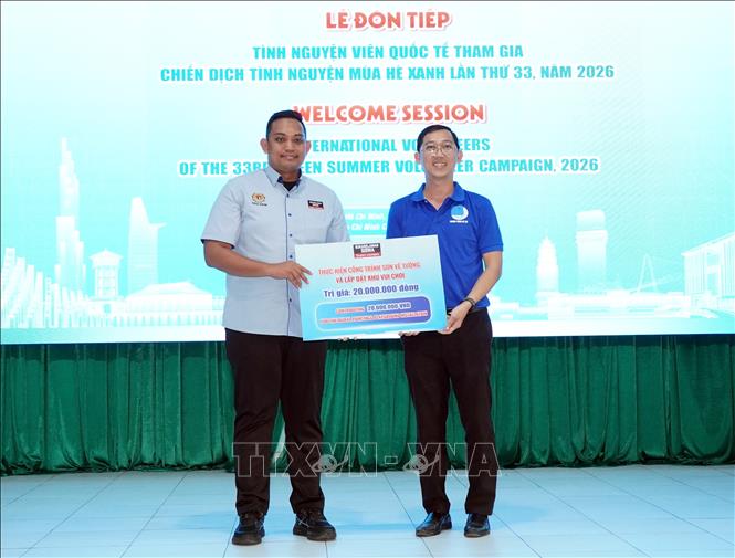 Đại diện tổ chức Sinh viên tình nguyện YSS trao bảng tượng trưng hỗ trợ thực hiện công trình sơn vẽ tường và lắp đặt khu vui chơi trị tại phường Trung Mỹ Tây. Ảnh: Trung Tuyến - TTXVN
