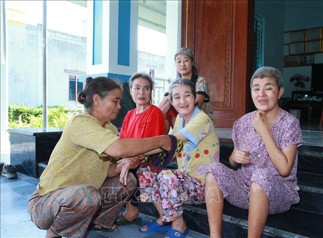 Bà Nguyễn Thị Đàn, xã Quảng Trung (Thanh Hóa) đang chăm sóc bốn đứa con gái bị ảnh hưởng chất độc da cam từ chồng là bệnh binh Lê Đình Dểnh. Ảnh: Trọng Đức - TTXVN