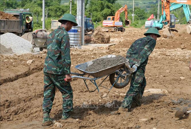 Các chiến sĩ Bộ chỉ huy Quân sự tỉnh Lai Châu vươt nắng mưa nhanh chóng hoàn thành nhiệm vụ. Ảnh: Nguyễn Oanh-TTXVN
