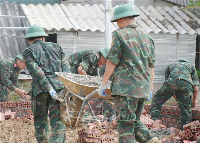 Bộ đội làm việc xuyên ngày đêm để xây nhà cho người dân Mường Than bị lũ quét vừa qua. Ảnh: Nguyễn Oanh-TTXVN