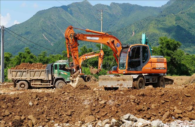 Nhiều máy móc được huy động đến công trường để đẩy nhanh tiến độ xây nhà cho người dân vùng lũ. Ảnh: Nguyễn Oanh-TTXVN