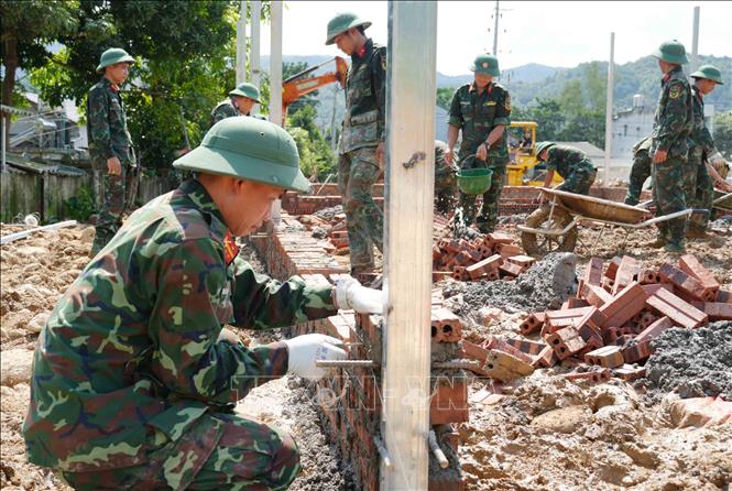 Các chiến sĩ Bộ chỉ huy Quân sự tỉnh Lai Châu vươt nắng mưa nhanh chóng hoàn thành nhiệm vụ xây nhà cho dân. Ảnh: Nguyễn Oanh-TTXVN

