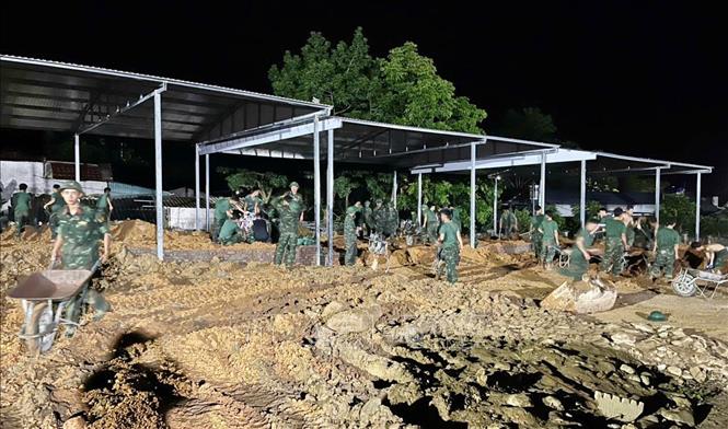 Bộ đội làm việc xuyên ngày đêm để xây nhà cho người dân Mường Than bị lũ quét vừa qua. Ảnh: Nguyễn Oanh-TTXVN