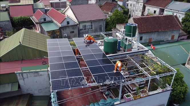 Công nhân Công ty Điện lực Nghệ An lắp đặt hệ thống điện mặt trời mái nhà cho khách hàng tại phường Trường Vinh, góp phần phát triển điện mặt trời tự sản, tự tiêu trên địa bàn tỉnh. Ảnh: Huy Hùng - TTXVN