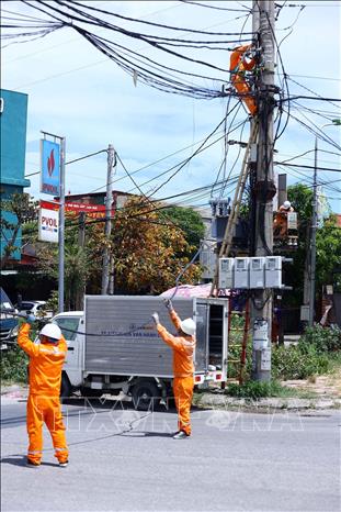 Công nhân Điện lực Cửa Lò (PC Nghệ An) thi công kéo dây cấp điện cho khách hàng mới, góp phần mở rộng khả năng tiếp cận điện năng phục vụ phát triển sản xuất và đời sống. Ảnh: Huy Hùng - TTXVN