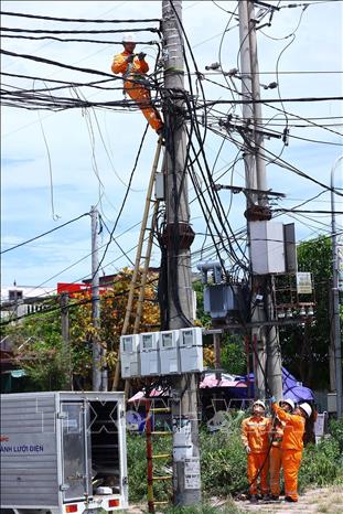 Công nhân Điện lực Cửa Lò (PC Nghệ An) thi công kéo dây cấp điện cho khách hàng mới, góp phần mở rộng khả năng tiếp cận điện năng phục vụ phát triển sản xuất và đời sống. Ảnh: Huy Hùng - TTXVN