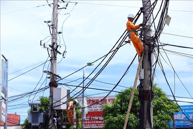 Công nhân Điện lực Cửa Lò (PC Nghệ An) kiểm tra, xử lý khiếm khuyết trên tuyến đường dây trung thế, nâng cao độ tin cậy cung cấp điện trong mùa nắng nóng. Ảnh: Huy Hùng - TTXVN