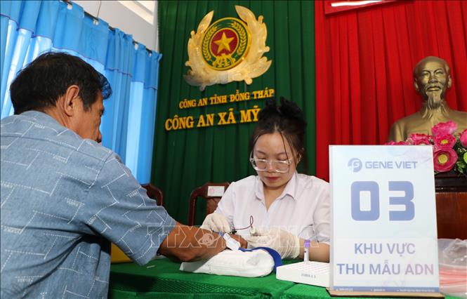 Lực lượng chuyên môn lấy mẫu sinh phẩm thân nhân liệt sĩ. Ảnh: Hồng Thái - TTXVN