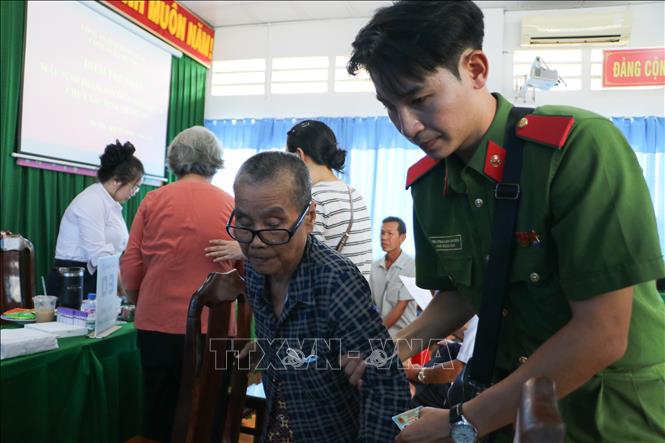 Lực lượng công an hỗ trợ thân nhân liệt sĩ tại các điểm lấy mẫu. Ảnh: Hồng Thái - TTXVN