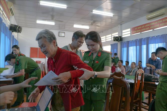 Lực lượng công an hỗ trợ thân nhân liệt sĩ tại các điểm lấy mẫu. Ảnh: Hồng Thái - TTXVN