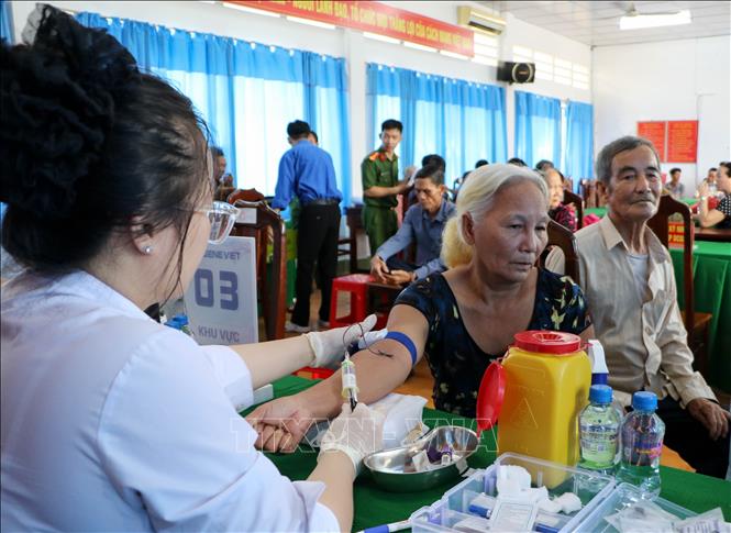 Lực lượng chuyên môn thực hiện lấy mẫu sinh phẩm thân nhân liệt sĩ. Ảnh: Hồng Thái - TTXVN