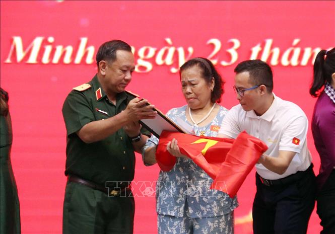 Bà Nguyễn Thị Thuật (nhân vật trong bài viết) xúc động đón nhận di ảnh chồng là liệt sĩ Hoàng Văn Khế. Ảnh: Xuân Khu - TTXVN