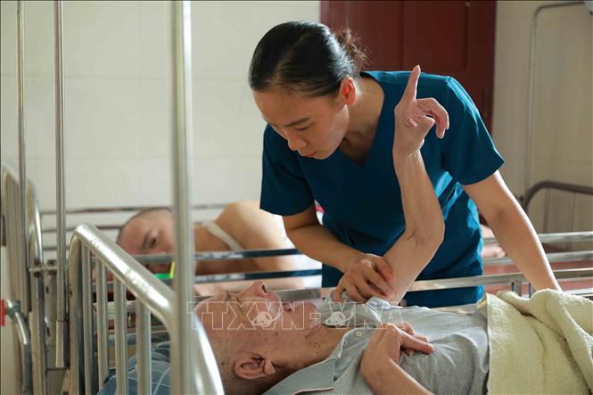 Công việc chăm sóc các cụ nằm liệt giường đòi hỏi sự kiên trì, tận tụy của đội ngũ nhân viên. Ảnh: Hữu Quyết - TTXVN