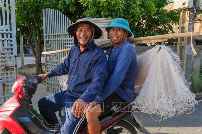 Ngư dân phường Hải Ninh cùng nhau mang ngư cụ ra biển để kéo lưới rùng. Ảnh: Hữu Quyết – TTXVN
