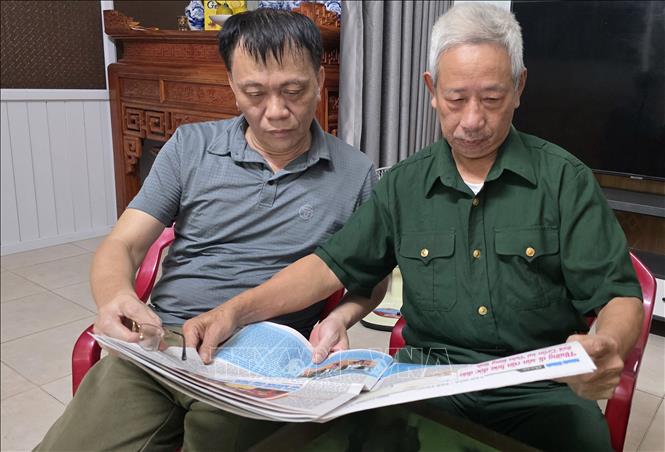 Cựu chiến binh Vũ Doanh Hùng cùng đồng đội đọc báo, trao đổi những tin tức hàng ngày. Ảnh: Công Luật - TTXVN
