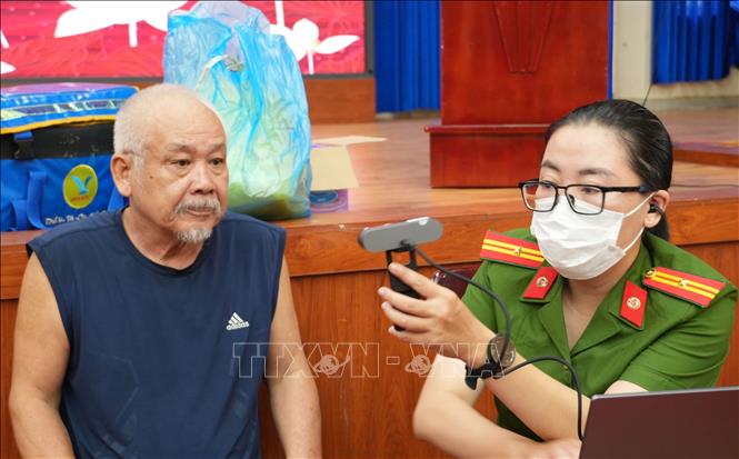Công an tỉnh Khánh Hòa kiểm tra sinh trắc học của thân nhân liệt sĩ trước khi tiến hành lấy mẫu sinh phẩm ADN. Ảnh: Phan Sáu - TTXVN 