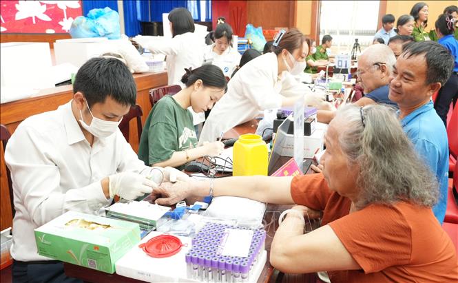 Thân nhân liệt sĩ cho mẫu sinh phẩm, nhằm góp phần xây dựng, làm giàu ngân hàng gen phục vụ hiệu quả công tác tìm kiếm, xác định danh tính hài cốt các anh hùng liệt sĩ. Ảnh: Phan Sáu - TTXVN 