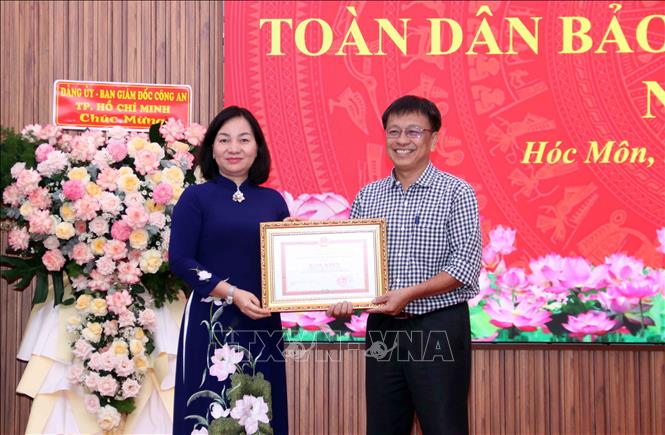 Tặng Bằng khen của UBND Thành phố cho đại diện tập thể cán bộ, nhân dân xã Hóc Môn vì có thành tích xuất sắc trong công tác bảo vệ an ninh Tổ quốc. Ảnh: Xuân Khu-TTXVN