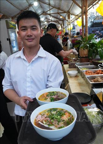 Đưa các tô bún bò Huế đi phục vụ du khách. Ảnh: Nguyên Lý - TTXVN