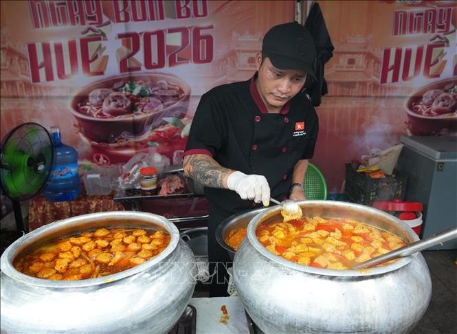 Cho nguyên liệu vào nồi nước dùng cho bún bò Huế. Ảnh: Nguyên Lý - TTXVN
