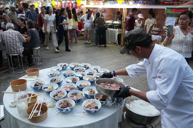 Đầu bếp cho nguyên liệu vào các tô bún bò Huế. Ảnh: Nguyên Lý - TTXVN