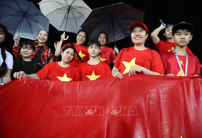 Mưa lớn không ngăn được tinh thần cổ vũ của các cổ động viên áo đỏ sao vàng. Ảnh: Đỗ Sinh – P/v TTXVN tại Thái Lan