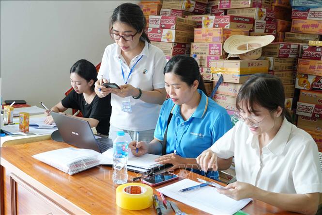 Kiểm đếm nhu yếu phẩm, tiền mà các nơi ủng hộ cho bà con vùng lũ Mường Than. Ảnh: Nguyễn Oanh - TTXVN 