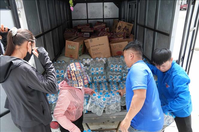 Các bạn đoàn viên, thanh niên bốc xếp hàng hóa và đưa đến những địa điểm cần thiết. Ảnh: Nguyễn Oanh - TTXVN 