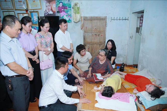 Các đoàn thể, tổ chức, cá nhân thăm hỏi, tặng quà bà Hoàng Thị Gấm ở tổ dân phố Cốc Hạ, phường Đông Hương, đang nuôi dưỡng 2 con gái là nạn nhân chất độc da cam bị nhiễm từ người chồng đi bộ đội ở chiến trường phía Nam (đã mất). Ảnh: Trọng Đức - TTXVN