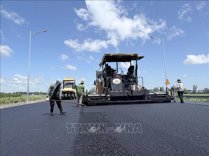 Nhà thầu đẩy nhanh thi công thảm nhựa đường dẫn vào tuyến cao tốc Châu Đốc - Cần Thơ - Sóc Trăng tại phường Vĩnh Tế, tỉnh An Giang. Ảnh: Thanh Sang - TTXVN