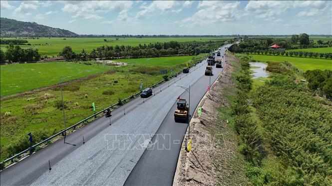Nhà thầu khẩn trương thảm nhựa đường dẫn từ Quốc lộ 91 vào điểm đầu tuyến cao tốc Châu Đốc - Cần Thơ - Sóc Trăng, đoạn qua phường Vĩnh Tế, tỉnh An Giang. Ảnh: Thanh Sang - TTXVN