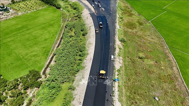 Nhà thầu đẩy nhanh thi công thảm nhựa đường dẫn từ Quốc lộ 91 (phường Vĩnh Tế, tỉnh An Giang) vào điểm đầu tuyến cao tốc Châu Đốc - Cần Thơ - Sóc Trăng. Ảnh: Thanh Sang - TTXVN
