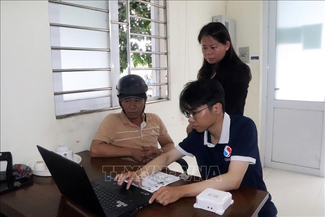 Nhân viên Công ty Hiệp lực phát triển Việt hướng dẫn cho ngư dân cài đặt, sử dụng phần mềm nhật ký khai thác điện tử. Ảnh: Đoàn Mạnh Dương-TTXVN