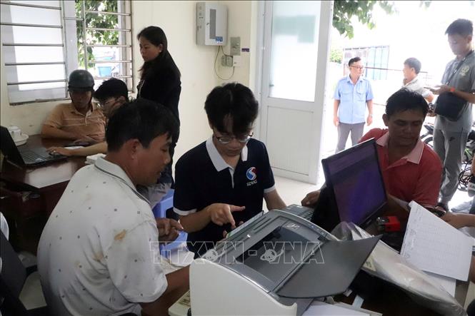 Nhân viên Công ty Hiệp lực phát triển Việt hướng dẫn cho ngư dân cài đặt, sử dụng phần mềm nhật ký khai thác điện tử. Ảnh: Đoàn Mạnh Dương-TTXVN