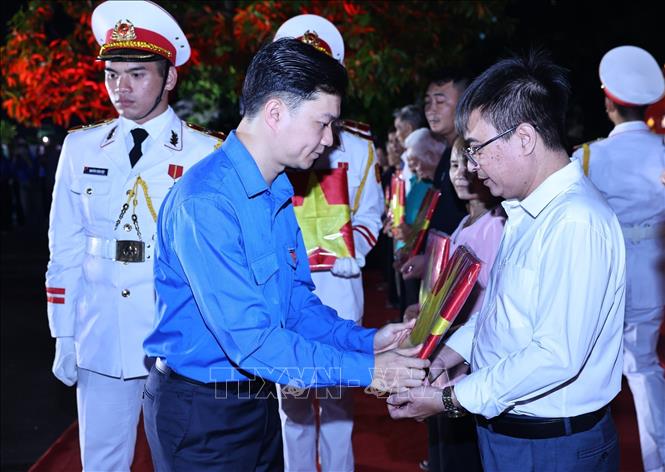 Đồng chí Nguyễn Minh Triết, Ủy viên dự khuyết Trung ương Đảng, Bí thư thường trực Trung ương Đoàn trao di ảnh cho các nhân thân liệt sĩ. Ảnh: Minh Đức - TTXVN