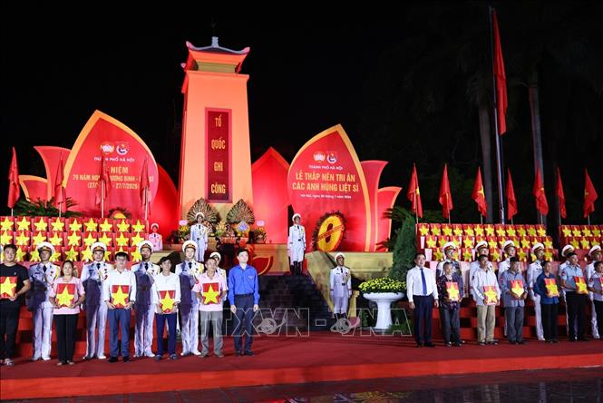 Đồng chí Trần Đức Thắng, Ủy viên Bộ Chính trị, Bí thư Thành uỷ, Trưởng đoàn Đại biểu Quốc hội thành phố Hà Nội và đồng chí Nguyễn Minh Triết, Ủy viên dự khuyết Trung ương Đảng, Bí thư thường trực Trung ương Đoàn trao di ảnh cho các nhân thân liệt sĩ. Ảnh: Minh Đức - TTXVN

