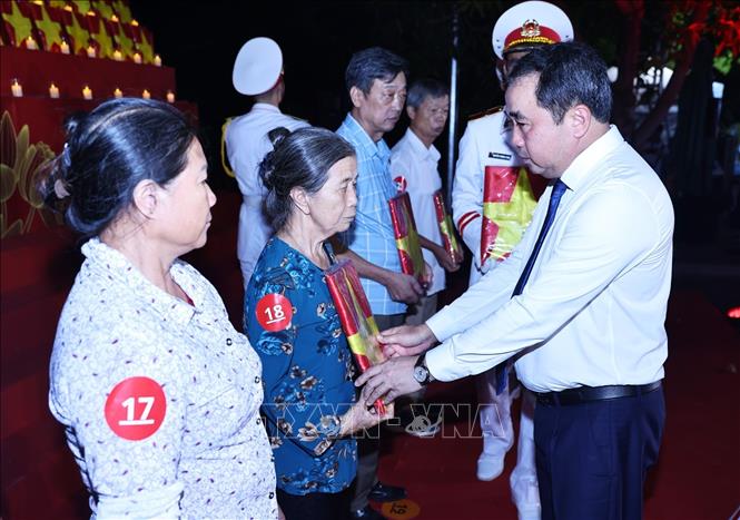 Đồng chí Trần Đức Thắng, Ủy viên Bộ Chính trị, Bí thư Thành uỷ, Trưởng đoàn Đại biểu Quốc hội thành phố Hà Nội trao di ảnh cho các nhân thân liệt sĩ. Ảnh: Minh Đức - TTXVN