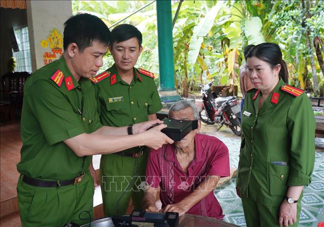 Cán bộ, chiến sĩ Công an tỉnh Cà Mau đến nhà làm căn cước cho người nhà yếu, bệnh tật. Ảnh: TTXVN phát.
