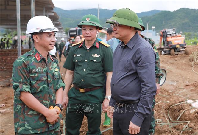 Đại diện Học viện Hậu cần lên hỗ trợ xây nhà cho bà con vùng lũ báo cáo về tiến độ với Bí thư Tỉnh ủy Lên Minh Ngân. Ảnh: Quý Trung – TTXVN