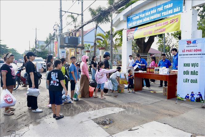 Đông đảo người dân ở thành phố Đồng Nai mang rác thải tái chế đến điểm đổi quà. Các em nhỏ ở thành phố Đồng Nai cũng được người lớn hướng dẫn đem rác đổi quà để bảo vệ môi trường. Ảnh: Lê Xuân-TTXVN