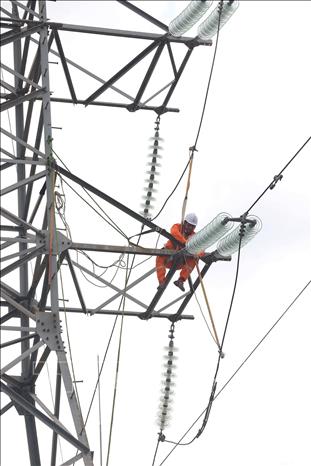 Công tác chuẩn bị để thực hiện vệ sinh sứ cách điện trên đường dây 110kV ở xã Hải Quang, tỉnh Ninh Bình. Ảnh: Vũ Sinh - TTXVN
