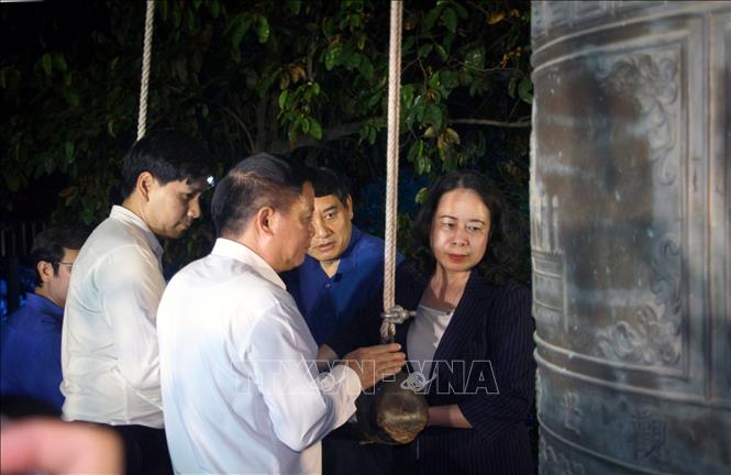 Vice President Vo Thi Anh Xuan and delegates ring a bell to pray for martyrs' souls at the candlelight ceremony. VNA Photo: Văn Tý